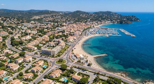Photographie terrestre ou aérienne de la commune côtière de Cavalaire-sur-Mer dans le Var, mettant en évidence le littoral méditerranéen, les bâtiments commerciaux et résidentiels, les routes d'accès principales, et l'environnement urbain balnéaire caractéristique de la région. L'image doit clairement identifier Cavalaire-sur-Mer comme une zone accessible et implantée, démontrant la pertinence géographique d'un magasin de pièces automobiles de proximité situé dans ce secteur côtier varois. Aucun texte, logo ou filigrane visible.