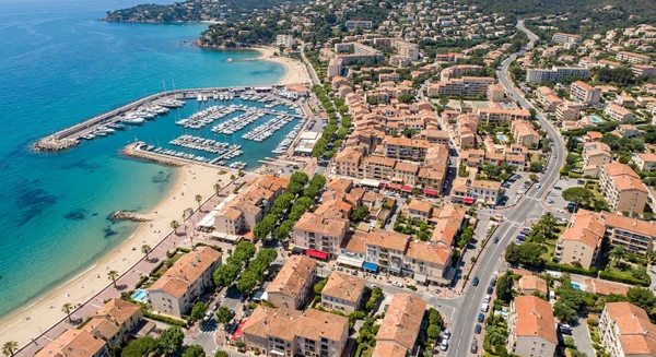 Photographie terrestre ou aérienne de la commune du Lavandou dans le Var, montrant un paysage côtier ou balnéaire caractéristique de la région avec bâtiments, commerces locaux, routes d'accès et environnement urbain varois. L'image doit clairement identifier Le Lavandou comme une zone accessible et implantée, démontrant la pertinence géographique d'un magasin de pièces automobiles de proximité situé dans ce secteur. Aucun texte, logo ou filigrane visible.